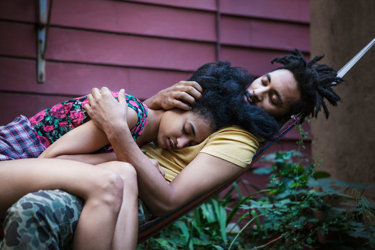 Couple in garden sleeping in hammock 