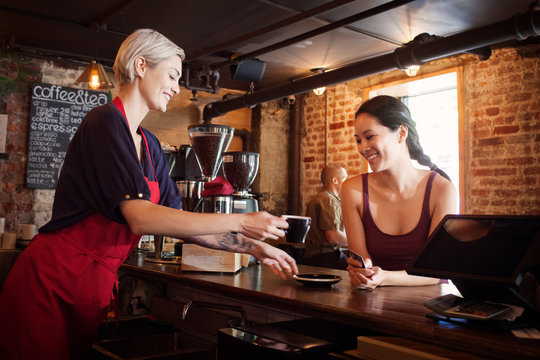 Woman serving coffee at cafe 