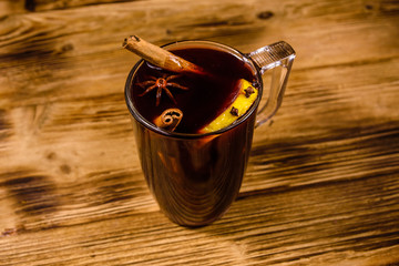 Cup of mulled wine with cinnamon on wooden table