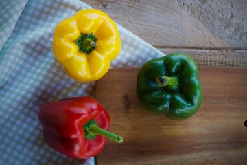 colorful bell peppers on wooden background