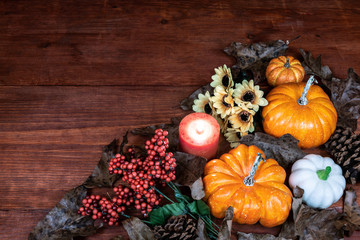 Thanksgiving decor with candle, pine cones, sunflowers, acorns, pumpkins, squash, guard, berries and  leaves