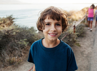 Smiling girl looking at camera and man with children in background 