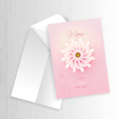 Top view of Mother's Day greeting card design with envelope on white wooden texture background.