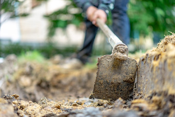 gardener digs the soil with his equipment for gardening and prepare land for plantation.