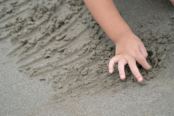 close up kid's hand and fingers, play and learn at the beach.