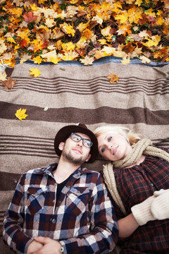 Couple laying on blanket in autumn 