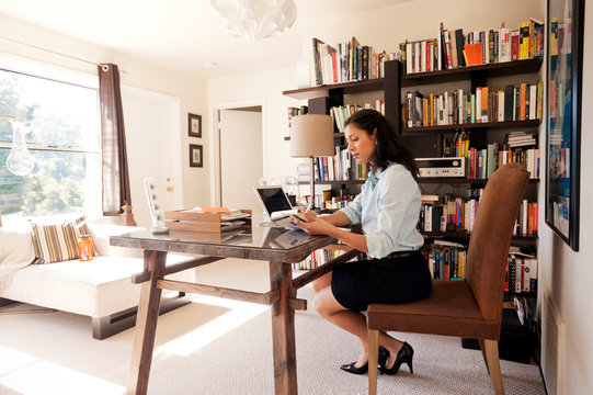 Woman sitting at desk writing in notepad 