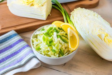 Bowl of Chinese cabbage salad with lemon and green onions - traditional Japanese vegetarian appetizer.