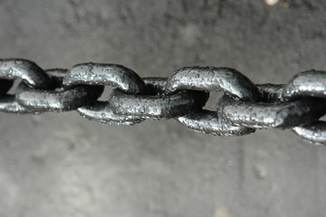 Powerful black steel chain in the rain with water droplets