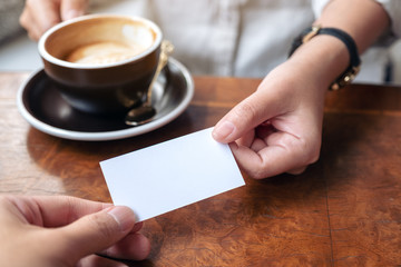 Obraz premium A woman holding and giving empty business card to someone