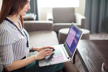 Fototapeta premium business, technology, internet and hotel concept - confident caucasian female entrepreneur typing letter to her boss on portable computer about about the results of business meeting
