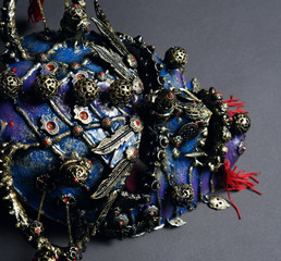 Naklejka premium Iron demon mask with precious stones on dark background