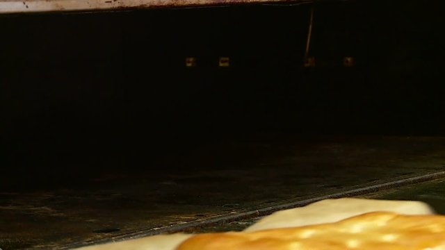 a worker in the bakery makes cheesecake pies and bakes them in the oven