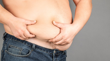 fat man, checking his weight, on a gray background