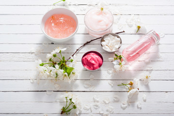 Fototapeta na wymiar beauty products and cherry blossom on white wood table