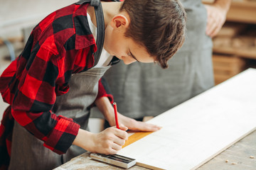profession, carpentry, woodwork and family concept - carpentery masterclass for little children and their fathers to share basic knowledge of working with wood.