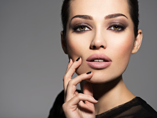 Face of a beautiful girl with fashion makeup and black nails