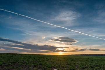 A scenic winter sunset over a large meadow.
