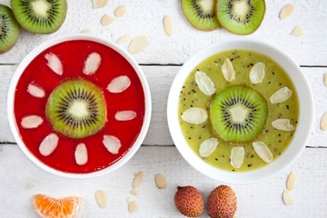 Smoohtie bowls z mrożonych truskawek i kiwi z plasterkami kiwi ozdobione owocami i płatkami migdałów