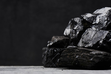 Natural coal on a black background isolated closeup. Extraction of natural mineral resources.
