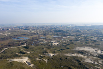 Obraz premium Dutch dunes by the sea from above in mystical late afternoon sun