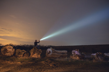 Man with flashlight in outdoor at night - obrazy, fototapety, plakaty