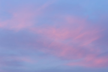 Background of blue sky with pink clouds at the golden hour.