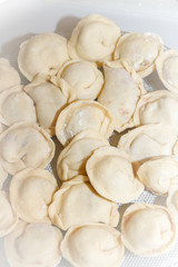 Raw and fresh dumplings lie on a glass plate