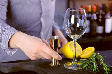 Ingredients for a cocktail with lemon and rosmary on board in bar.