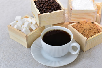 Black coffee with the wooden box of sugar and roasted coffee beans