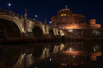 Obraz premium beautiful view of Castel Sant'Angelo and the bridge at night with reflections on the Tiber river. Rome Italy