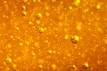 Abstract macro honey bubbles closeup in bright amber color. The texture of the honey. Healthy food...