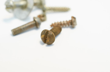 old rusty bolts, nuts and screws lie on gray background