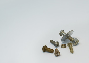old rusty bolts, nuts and screws lie on gray background