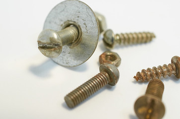 old rusty bolts, nuts and screws lie on gray background