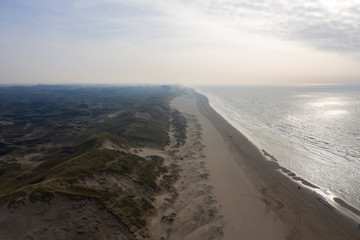 Dutch dunes by the sea from above in mystical late afternoon sun