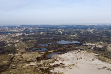 Dutch dunes by the sea from above in mystical late afternoon sun