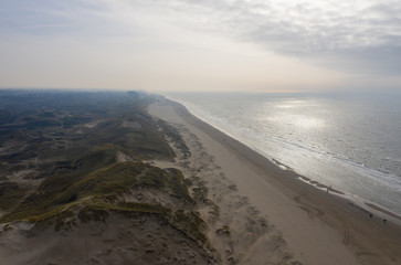 Dutch dunes by the sea from above in mystical late afternoon sun