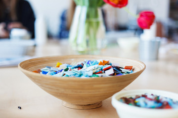 Plate with colored ceramic mosaic on the table in the creative workshop.