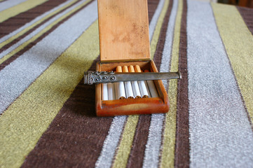 silver vintage mouthpiece. mouthpiece lying on a vintage wooden cigarette box