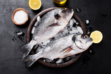 Fresh uncooked dorado or sea bream fish with lemon .