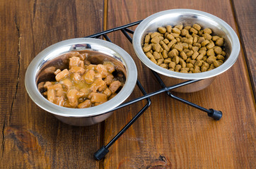Metal bowls with various pet food.