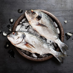 Fresh uncooked dorado or sea bream fish with lemon .