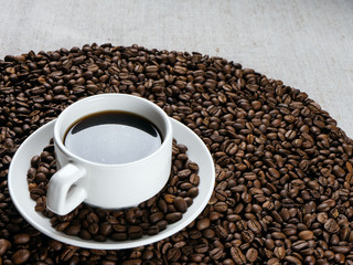 Coffee cup and beans on old kitchen table.