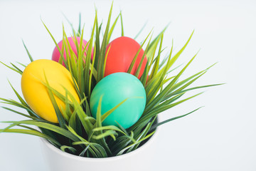 Top view of Easter eggs clean in grass on white wooden background