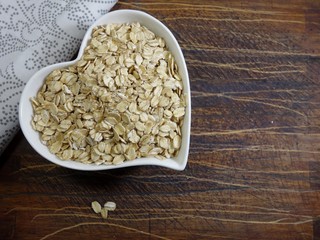 Pile of oatmeal in a heart shaped dish. Concept of healthy eating, vegan food, healthy food. Top view