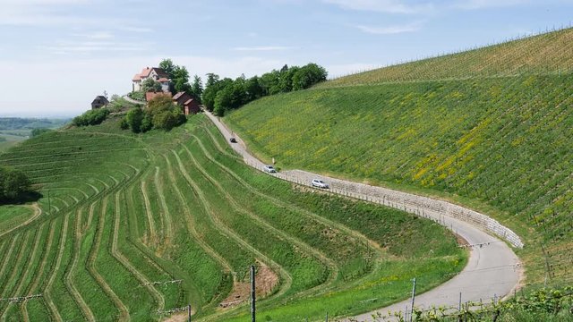 DURBACH, GERMANY - CIRCA 2019: Burg Schloss Staufenberg castle in Baden Wurttemberg village - elevated still drone view with cars on the serpentine road and sunny weather over the winery roads
