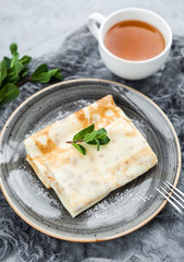 Crepes or russian pancakes with a hot cup of tea