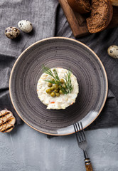 Olivier Russian with rye bread and quail eggs on a gray background