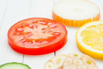 Sliced fruits, vegetables on white wooden table